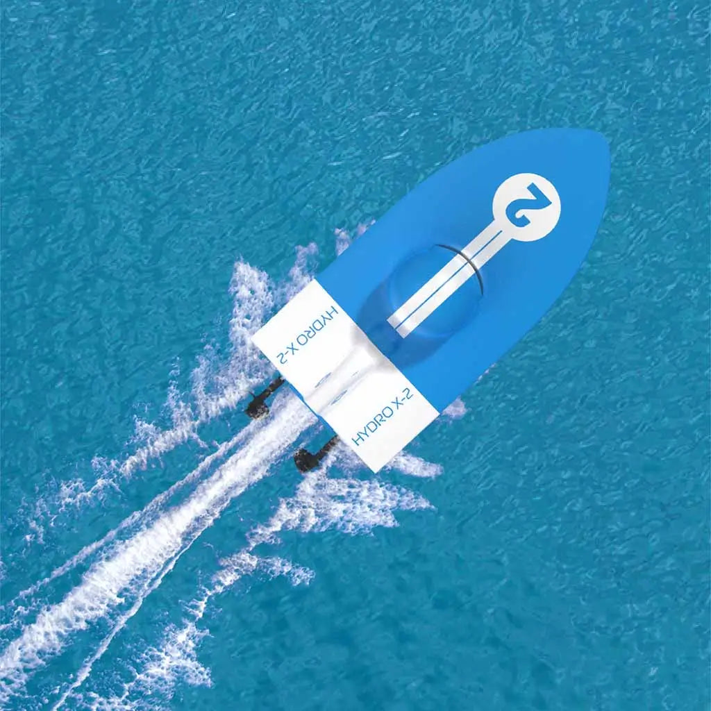 Sharper Image X-Treme Hydro Racer RC boat racing across bright blue water, leaving a white wake trail behind its twin motors for a high-speed hydro racing effect.