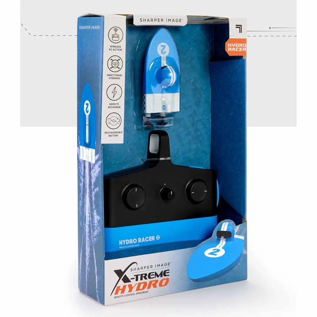 Retail packaging of Sharper Image X-Treme Hydro Racer RC boat showing the blue speedboat and black controller inside box, with labeled features like rechargeable battery and steering control.