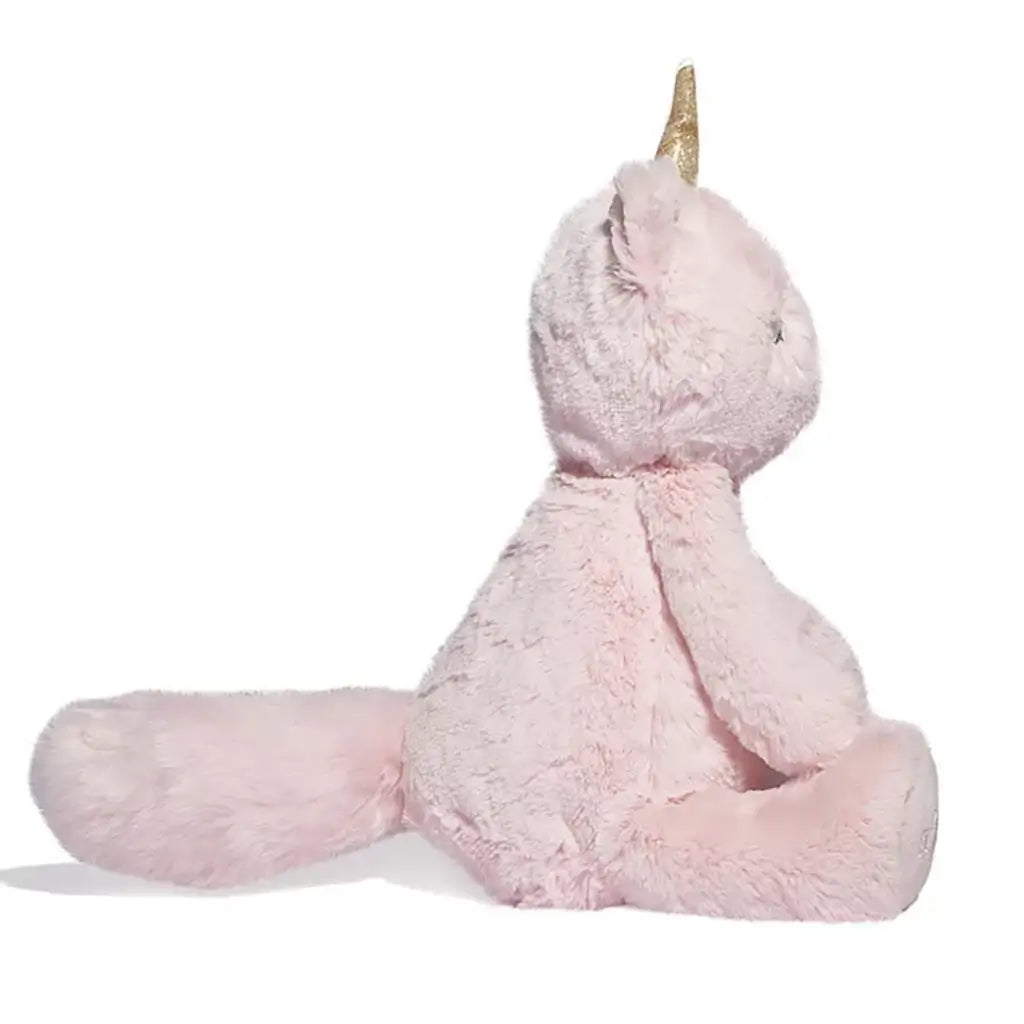 Fuzzy pastel pink unicorn cat plush with golden horn and long fluffy tail shown from the left side, highlighting its soft, huggable texture.