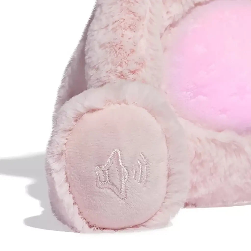 Close-up of plush unicorn cat’s paw embroidered with music note symbol, showing sound activation feature stitched on soft pink fur.