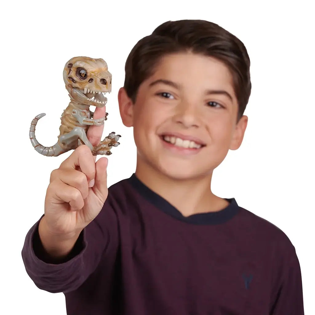 Close-up of the Untamed Fingerlings Doom Skeleton Dinosaur figure, a bone-white T-Rex with brown shading, detailed claws, and a fierce expression with sharp teeth and expressive orange eyes.